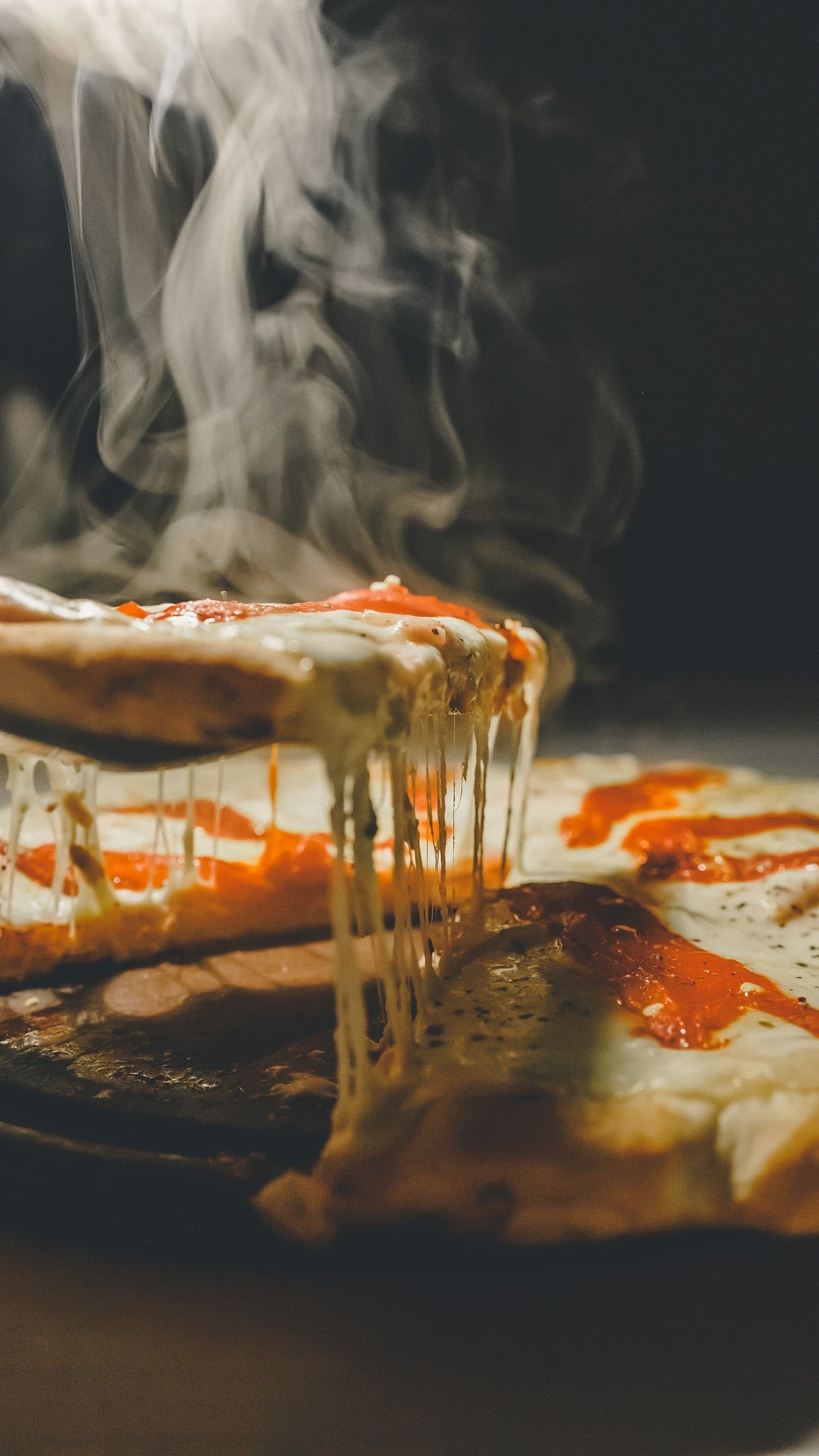 A slice of pizza pulled from the pie